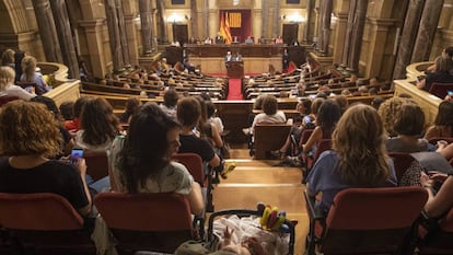 Una mujer con su hijo sigue el pleno especial en el Parlament en defensa del movimiento feminista