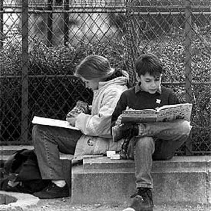 Dos alumnos estudian en un parque de París.