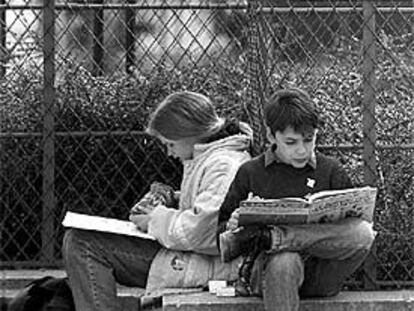 Dos alumnos estudian en un parque de París.