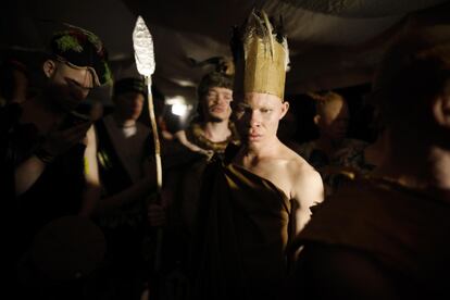 Varios hombres albinos esperan entre bastidores para salir a desfilar.