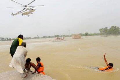 Los equipos de rescate ayudan a los superviventes de las inundaciones en la región pakistaní de Khangarh (este). El país conmemora hoy el 63º aniversario de su Independencia, pero el Gobierno ha suspendido todos los actos de celebración a causa de la tragedia.