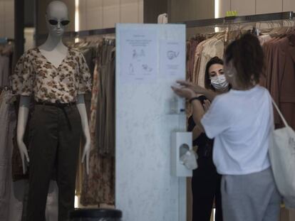 Una clienta a l'entrada d'una botiga de roba al passeig de Gràcia de Barcelona.