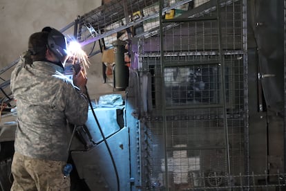 A mechanic from the Ukrainian 46th Brigade installs an anti-drone grille on an armored vehicle, on October 18.