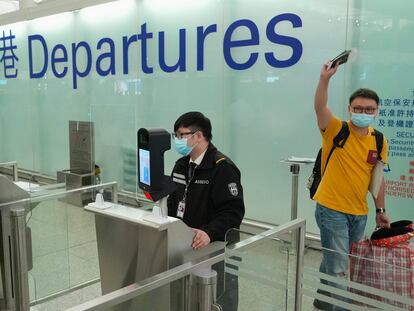 Un hombre se despide antes de embarcar en el aeropuerto de Hong Kong para trasladarse de manera definitiva al Reino Unido este miércoles