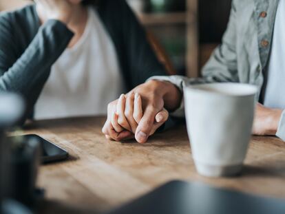 Una pareja se coge la mano.