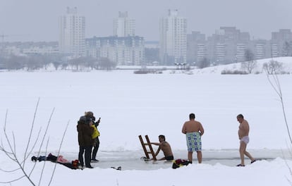 Varios hombres se bañan en las aguas congeladas de un lago durante la celebración de la Epifanía, en Minsk (Bielorrusia).