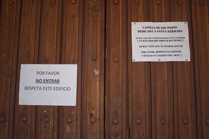 Carteles de la Capilla de los Pozos expuestos en la puerta. Tras el abandono del poblado el pillaje de algunos edificios obligó al párroco a poner en la puerta un cartel rogando respeto por el interior de la iglesia.