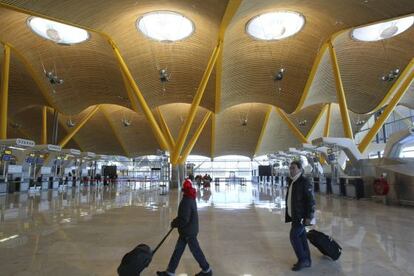Dos pasajeros caminan por la terminal T4 en el aeropuerto de Barajas en Madrid.