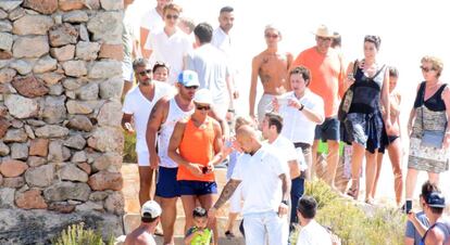 Cristiano Ronaldo, con camiseta naranja, rodeado de curiosos durante un paseo por Formentera.