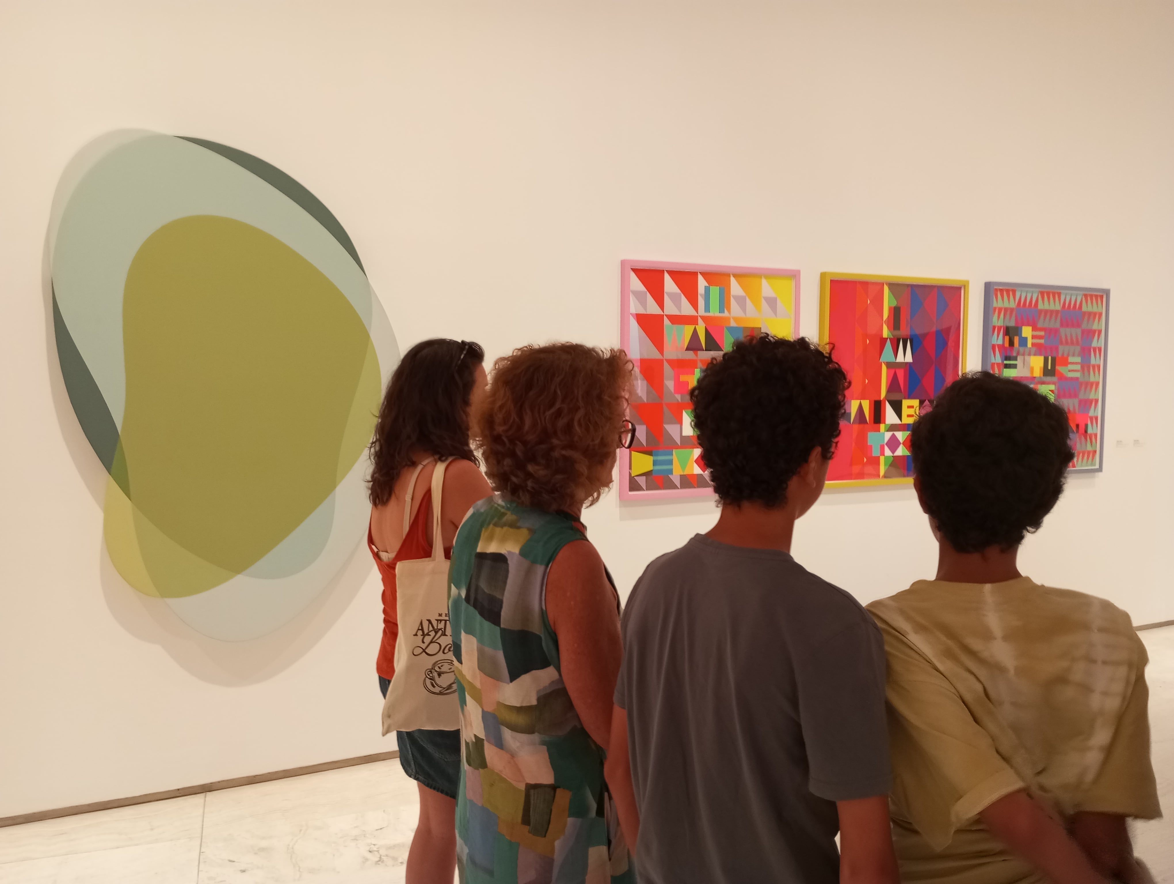Asistentes observan las obras expuestas en la muestra 'Coloramas', en el MACA.