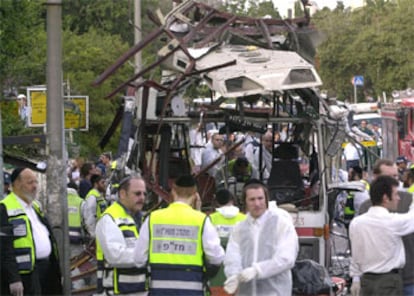 Miembros de las fuerzas de seguridad, ante los restos del autobs siniestrado.