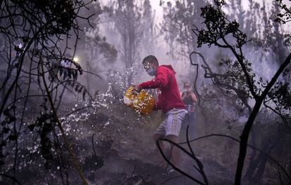 TOPSHOT - People try to put out a forest fire in Bogota, in February 2, 2016. A yellow alert was declared Tuesday in Bogota due to the air pollution caused by a forest fire near the capital's downtown, where government buildings, schools and other entities were evacuated, authorities reported. AFP PHOTO/ Luis ACOSTA / AFP / LUIS ACOSTA