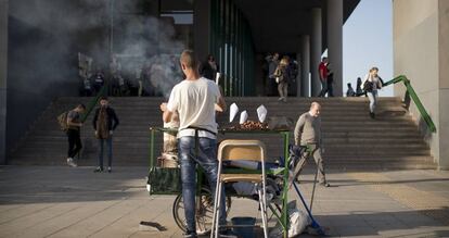 Un hombre vende castañas frente a la estación de buses Plaza de Armas de Sevilla.