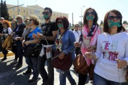 Trabajadores de organizaciones sociales se manifiestan encadenados y con mordazas en el centro de Atenas, durante una protesta el pasado 3 de abril. EFE/Archivo