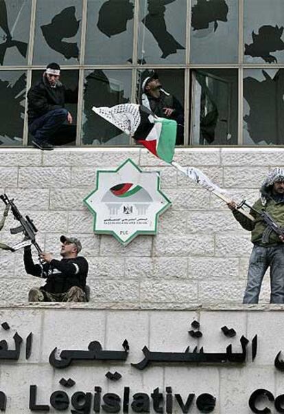 Militantes de Al Fatah, encaramados en la fachada principal del Parlamento palestino en Ramala.