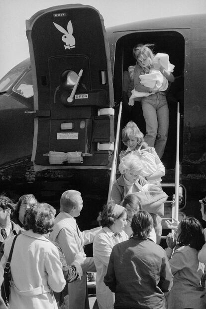 Playboy Bunnies Carrying Orphans Off Aircraft