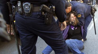 Dos polic&iacute;as arrojan al suelo a una estudiante durante las protestas del pasado febrero.