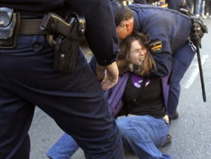 Dos polic&iacute;as arrojan al suelo a una estudiante durante las protestas del pasado febrero.