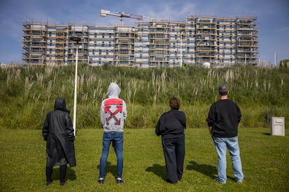 Cuatro cooperativistas del proyecto de alquiler social, ante una de las parcelas del barrio coruñés de Xuxán donde se deberían estar construyendo los edificios.
