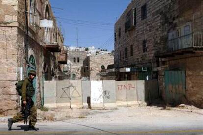 Muro instalado en una calle de Hebrón para proteger a los colonos donde una pintada dice: "Muerte a los árabes".