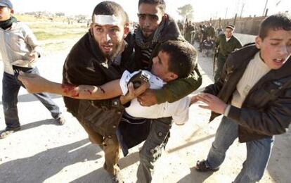Unos jóvenes palestinos trasladan a un herido de los enfrentamientos en la zona fronteriza de Rafah