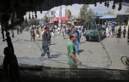 Un grupo de personas caminan junto a un autobús con vidrios rotos después de una explosión en Kabul (Afganistán). Al menos 14 personas han muerto y más de un centenar han resultado heridas este miércoles en un atentado perpetrado por los talibán contra una sede de la Policía en el oeste de la capital de Afganistán, Kabul, según ha confirmado el Ministerio de Sanidad.