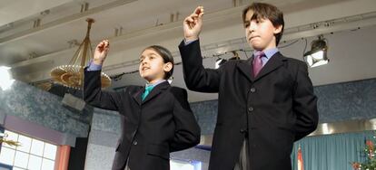 Pareja de niños de San Ildefonso cantando un premio.