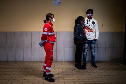 Un voluntario de la Cruz Roja espera en el departamento de emergencias del hospital para que los médicos visiten a una pareja de inmigrantes.