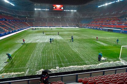 Los operarios de Osasuna despejan la nieve de El Sadar antes del partido contra el Madrid.