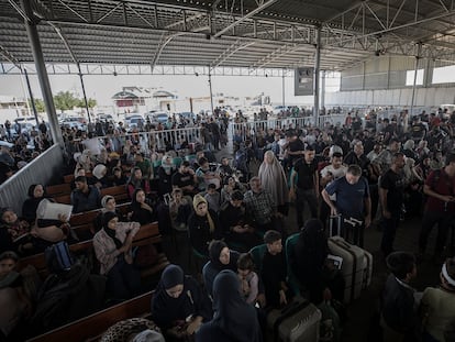 Decenas de ciudadanos aguardan en el paso fronterizo de Rafah para cruzar a Egipto desde la Franja, este miércoles.