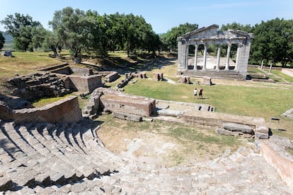 Madre e hijo explorando la antigua excavación arqueológica griega de Apolonia, de pie frente a las ruinas de un templo de Agonothetes, en Albania.