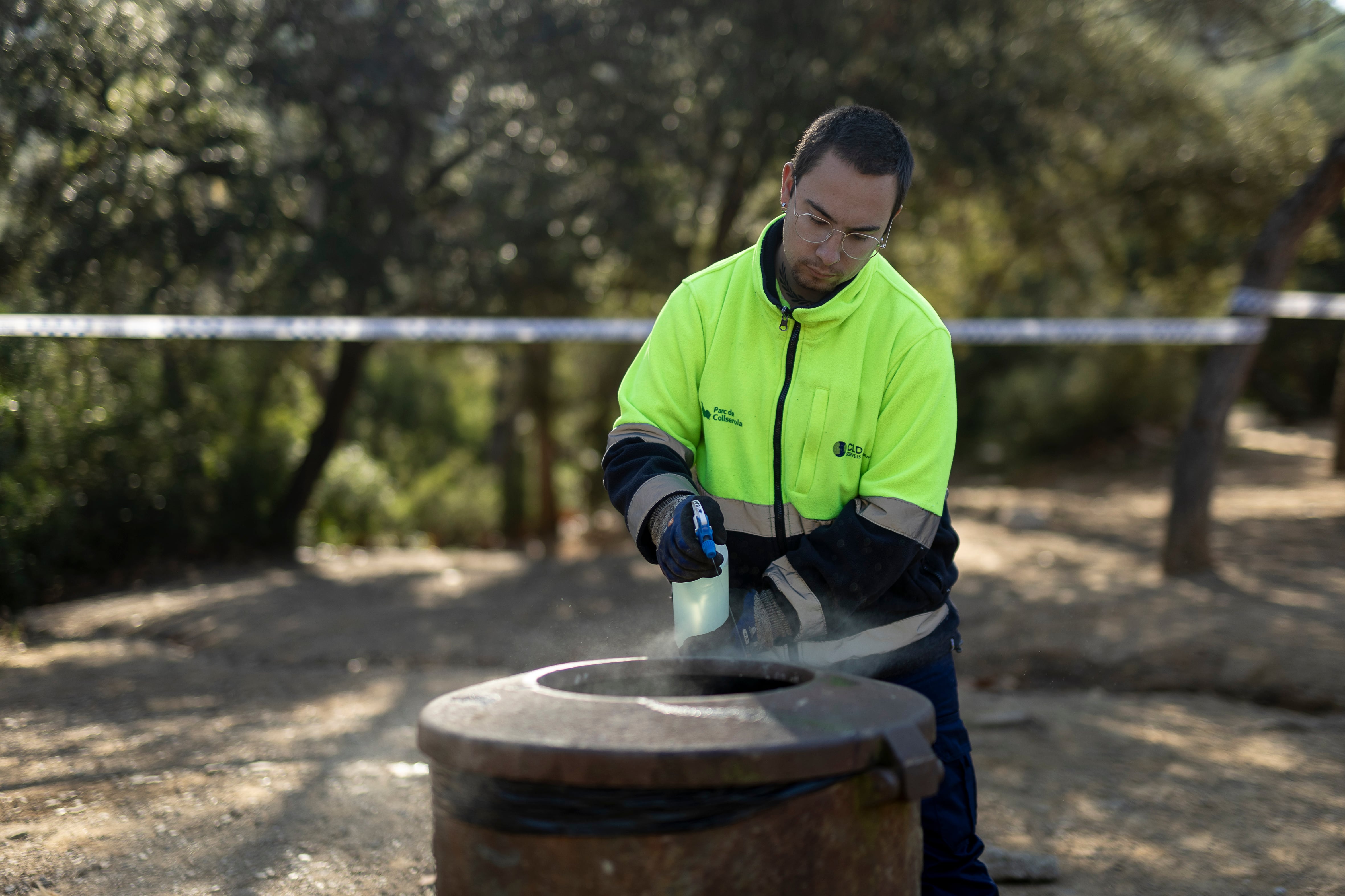 Una brigada del Parc de Collserola desinfecta las basuras del área de Can Coll, lugar de entrada al Parque Natural de Collserola donde está prohibido el paso por ser zona infectada por la peste porcina africana. [ALBERT GARCIA] 