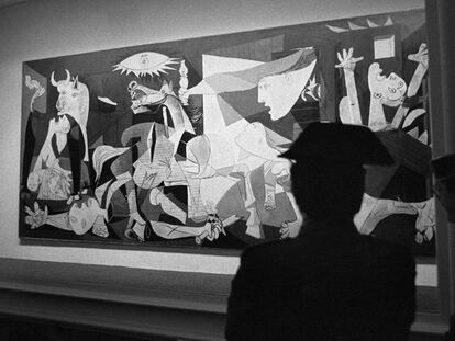 Agentes de la Guardia Civil vigilan la urna blindada que protege el &quot;Guernica&quot;, obra de Pablo Picasso, en su su presentaci&oacute;n en el emplazamiento del Cas&oacute;n del Buen Retiro de Madrid, tras su regreso a Espa&ntilde;a. 