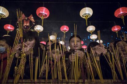 Varias personas rezan mientras queman incienso en el templo Wong Tai Sin para dar la bienvenida al Año Nuevo chino en la ciudad de Hong Kong.