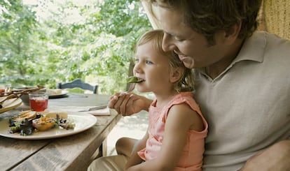 Padre da de comer a su hija. 