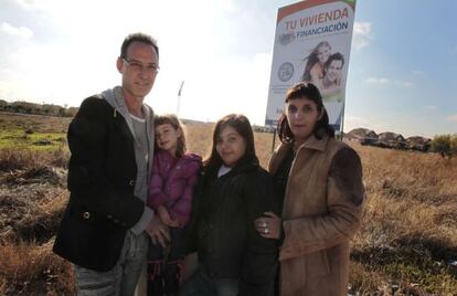 José Luis Blanco y Ruth Cuadrado, con sus dos hijas, junto al anuncio de una promoción inmobiliaria en Villanueva de la Torre.