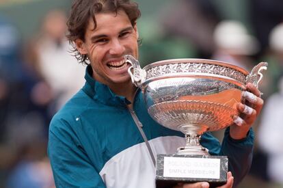 El tenista español Rafael Nadal muerde el trofeo del Roland Garros 2013 tras vencer a David Ferrer en la final.