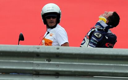 Pol Espargaro, con un collarín, abandona el circuito después del incidente con Márquez sobre el asfalto.