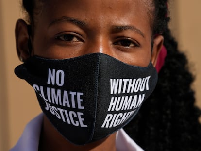 Una mujer se cubre con una mascarilla con el lema "No hay justicia climática sin derechos humanos" durante una protesta en la COP27, en Sharm el Sheij.