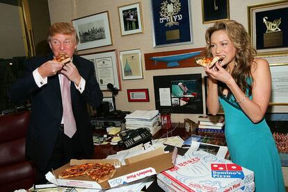 Donald Trump hincándole el diente a una pizza con Stephanie Myers, concursante de <i>El aprendiz</i>.