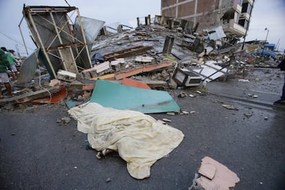 Un cuerpo cubierto cerca de unos edificios destruidos, en Pedernales el 17 de abril de 2016.