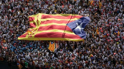Una inmensa bandera estelada pasa entre las manos de los participantes. Diada de Catalunya, imagnes alzadas de la Via catalana 2015.