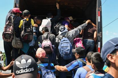 Un grupo de personas trata de entrar en un camión dirección a Estados Unidos, a 180 km de Tegucigalpa, el 13 de octubre de 2018. 