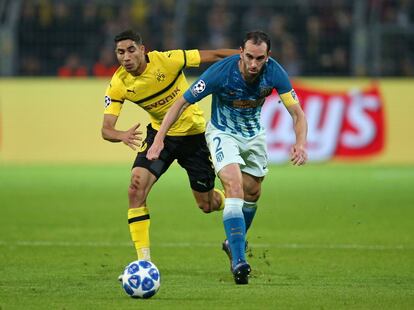 Diego Godín, del Atlético de Madrid, y Achraf Hakimi, del Borussia, luchan por hacerse con la posesión del balón.