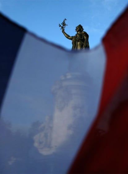 Estatua de la República en París, tras la bandera de Francia.