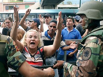 Soldados contienen a la gente que protesta en uno de los puntos de recogida de firmas contra Chávez.