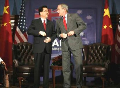 George W. Bush y Hu Jintao se abrochan las chaquetas al término de una reunión ayer en Sidney.