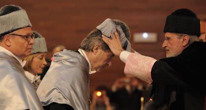 El rector de la Universitat de Val&egrave;ncia, Esteban Morcillo, pone el birrete de doctor al periodista I&ntilde;aki Gabilondo.