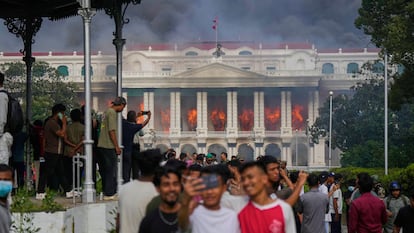 Manifestantes se toman fotos frente al Parlamento de Nepal en llamas, el pasado 9 de septiembre.