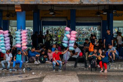 Un grupo de migrantes se protege de la lluvia en la plaza principal de Tapachula, Chiapas. 